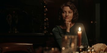 Movie still from “Guillermo del Toro's Cabinet of Curiosities” (2022), directed by Keith Thomas – A woman sitting in front of a table with a candle; Close Up shot, Over the shoulder angle
