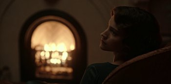 Movie still from “Guillermo del Toro's Cabinet of Curiosities” (2022), directed by Keith Thomas – A woman sitting in front of a fire place; Close Up shot, Over the shoulder angle
