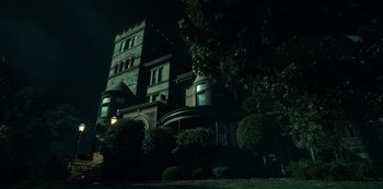 Movie still from “Guillermo del Toro's Cabinet of Curiosities” (2022), directed by Keith Thomas – A large building in the dark at night time; Extreme Wide shot, Low angle