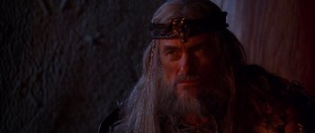 Movie still from “The Scorpion King” (2002), directed by Chuck Russell – An old man with long white hair wearing a crown; Close Up shot, Over the shoulder angle