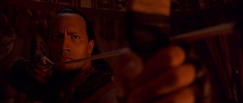 Movie still from “The Scorpion King” (2002), directed by Chuck Russell – A person holding a stick; Close Up shot, Low angle