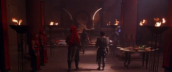 Movie still from “The Scorpion King” (2002), directed by Chuck Russell – A group of people standing in a room with fire; Wide shot, High angle