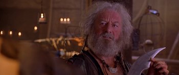 Movie still from “The Scorpion King” (2002), directed by Chuck Russell – An old man with a white beard is looking at the camera; Close Up shot, Over the shoulder angle