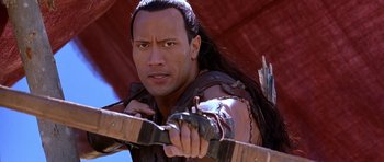 Movie still from “The Scorpion King” (2002), directed by Chuck Russell – A man holding a bow and arrow in a movie scene; Close Up shot, Over the shoulder angle