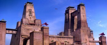 Movie still from “The Scorpion King” (2002), directed by Chuck Russell – An airplane flying over some buildings in a city; Extreme Wide shot, Low angle