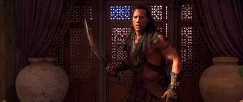 Movie still from “The Scorpion King” (2002), directed by Chuck Russell – A man holding a sword in front of an open door; Medium shot, Over the shoulder angle