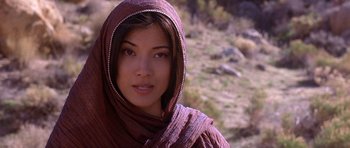 Movie still from “The Scorpion King” (2002), directed by Chuck Russell – A woman wearing a headscarf is standing in a field; Close Up shot, Low angle