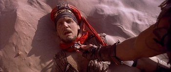 Movie still from “The Scorpion King” (2002), directed by Chuck Russell – A man with a red bandanna is laying on the ground; Close Up shot, High angle