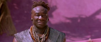 Movie still from “The Scorpion King” (2002), directed by Chuck Russell – A man with a bunch of beads around his neck; Close Up shot, Low angle