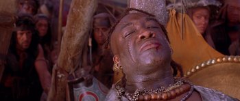 Movie still from “The Scorpion King” (2002), directed by Chuck Russell – A man with a face full of mud and beads; Close Up shot, Low angle