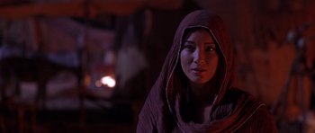 Movie still from “The Scorpion King” (2002), directed by Chuck Russell – A woman with a hood on looking into the distance; Close Up shot, Over the shoulder angle