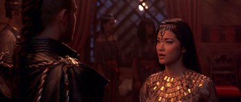 Movie still from “The Scorpion King” (2002), directed by Chuck Russell – A woman in a gold dress standing in front of a man; Close Up shot, Over the shoulder angle