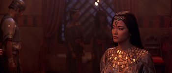 Movie still from “The Scorpion King” (2002), directed by Chuck Russell – A woman in a gold dress standing in front of two other women; Close Up shot, Over the shoulder angle