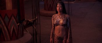Movie still from “The Scorpion King” (2002), directed by Chuck Russell – A woman in a costume stands next to a pillar; Medium shot, High angle