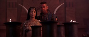 Movie still from “The Scorpion King” (2002), directed by Chuck Russell – A man and a woman standing in front of pots and pans; Medium shot, Low angle