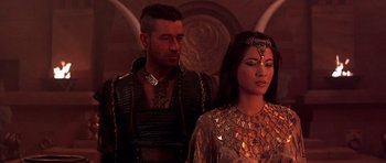Movie still from “The Scorpion King” (2002), directed by Chuck Russell – A man standing next to a woman wearing a gold dress; Close Up shot, Over the shoulder angle