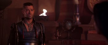Movie still from “The Scorpion King” (2002), directed by Chuck Russell – A man standing next to a fireplace in a room; Medium shot, Over the shoulder angle
