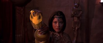 Movie still from “The Scorpion King” (2002), directed by Chuck Russell – A woman holding a snake in her hand; Close Up shot, Low angle