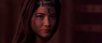 Movie still from “The Scorpion King” (2002), directed by Chuck Russell – A beautiful woman with long dark brown hair wearing an ornate headpiece; Close Up shot, Over the shoulder angle
