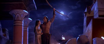 Movie still from “The Scorpion King” (2002), directed by Chuck Russell – A man and a woman are holding a bow and arrow; Medium shot, Over the shoulder angle