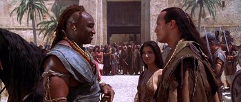 Movie still from “The Scorpion King” (2002), directed by Chuck Russell – A group of men and women standing next to each other in front of a crowd; Medium shot, Over the shoulder angle