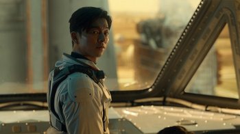 Movie still from “The Silent Sea” (2021), created by Choi Hang-Yong – A man standing in front of an airplane window; Close Up shot, Over the shoulder angle