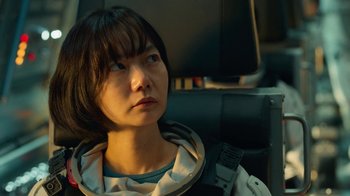 Movie still from “The Silent Sea” (2021), created by Choi Hang-Yong – A woman in a spacesuit looking off into the distance; Close Up shot, Over the shoulder angle