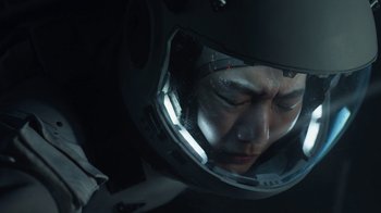 Movie still from “The Silent Sea” (2021), created by Choi Hang-Yong – A man wearing a helmet and a suit; Close Up shot, High angle
