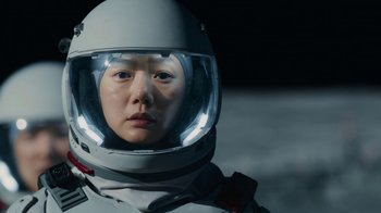 Movie still from “The Silent Sea” (2021), created by Choi Hang-Yong – A person wearing a space suit and a helmet; Close Up shot, Low angle