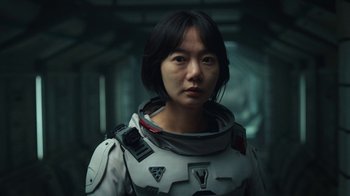 Movie still from “The Silent Sea” (2021), created by Choi Hang-Yong – A woman in a spacesuit is looking at the camera; Close Up shot, Over the shoulder angle