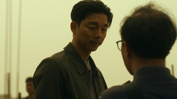 Movie still from “The Silent Sea” (2021), created by Choi Hang-Yong – A man in a green jacket talking to another man; Close Up shot, Over the shoulder angle