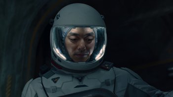 Movie still from “The Silent Sea” (2021), created by Choi Hang-Yong – A man in a spacesuit with a helmet on; Close Up shot, Overhead angle