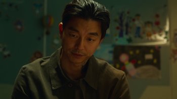 Movie still from “The Silent Sea” (2021), created by Choi Hang-Yong – A person wearing a brown shirt; Close Up shot, Over the shoulder angle