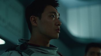 Movie still from “The Silent Sea” (2021), created by Choi Hang-Yong – A young man in a space suit looking up at the sky; Close Up shot, Low angle