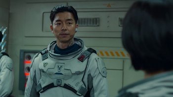Movie still from “The Silent Sea” (2021), created by Choi Hang-Yong – A man in a spacesuit is standing in front of a wall; Close Up shot, Over the shoulder angle