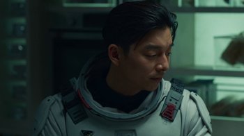Movie still from “The Silent Sea” (2021), created by Choi Hang-Yong – A man in a spacesuit looking down at his face; Close Up shot, Over the shoulder angle