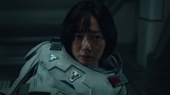 Movie still from “The Silent Sea” (2021), created by Choi Hang-Yong – A woman in a spacesuit is posing for a picture; Close Up shot, High angle