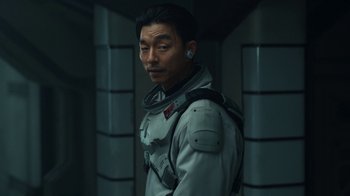 Movie still from “The Silent Sea” (2021), created by Choi Hang-Yong – A man in a space suit standing in a room; Close Up shot, Over the shoulder angle