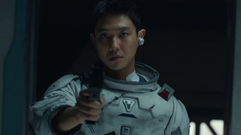 Movie still from “The Silent Sea” (2021), created by Choi Hang-Yong – A man in a spacesuit holding a remote control; Close Up shot, Low angle