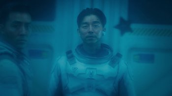 Movie still from “The Silent Sea” (2021), created by Choi Hang-Yong – A man in a spacesuit is standing in a room; Medium shot, High angle