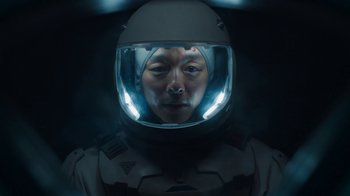 Movie still from “The Silent Sea” (2021), created by Choi Hang-Yong – A man wearing a helmet in a dark room; Close Up shot, Overhead angle