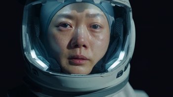 Movie still from “The Silent Sea” (2021), created by Choi Hang-Yong – A person wearing a space suit and a helmet; Close Up shot, High angle