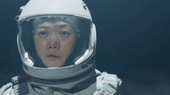 Movie still from “The Silent Sea” (2021), created by Choi Hang-Yong – A man in a spacesuit is looking at the camera; Close Up shot, Low angle