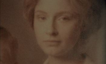 Movie still from “Guillermo del Toro's Cabinet of Curiosities” (2022), directed by Keith Thomas – An old photograph of a woman's face in sepia tone; Extreme Close Up shot, High angle