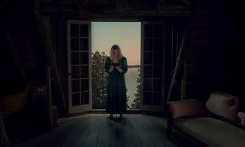 Movie still from “Guillermo del Toro's Cabinet of Curiosities” (2022), directed by Keith Thomas – A woman standing in front of an open door; Wide shot, Low angle