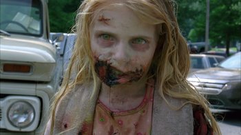 Movie still from “The Walking Dead” (2010), directed by Daniel Sackheim – A young girl with makeup on her face; Close Up shot, Over the shoulder angle