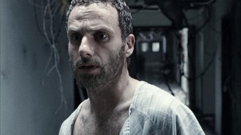 Movie still from “The Walking Dead” (2010), directed by Daniel Sackheim – A person with a beard looking at the camera; Close Up shot, Over the shoulder angle