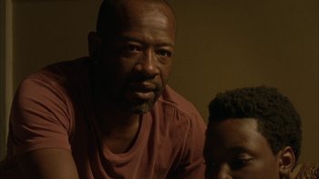 Movie still from “The Walking Dead” (2010), directed by Daniel Sackheim – A man and a boy sitting next to each other in front of a wall; Close Up shot, Over the shoulder angle