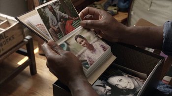 Movie still from “The Walking Dead” (2010), directed by Daniel Sackheim – A person is holding a book with pictures of people; Extreme Close Up shot, High angle