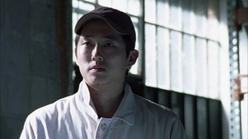 Movie still from “The Walking Dead” (2010), directed by Daniel Sackheim – A man wearing a baseball cap and a white shirt; Close Up shot, Low angle